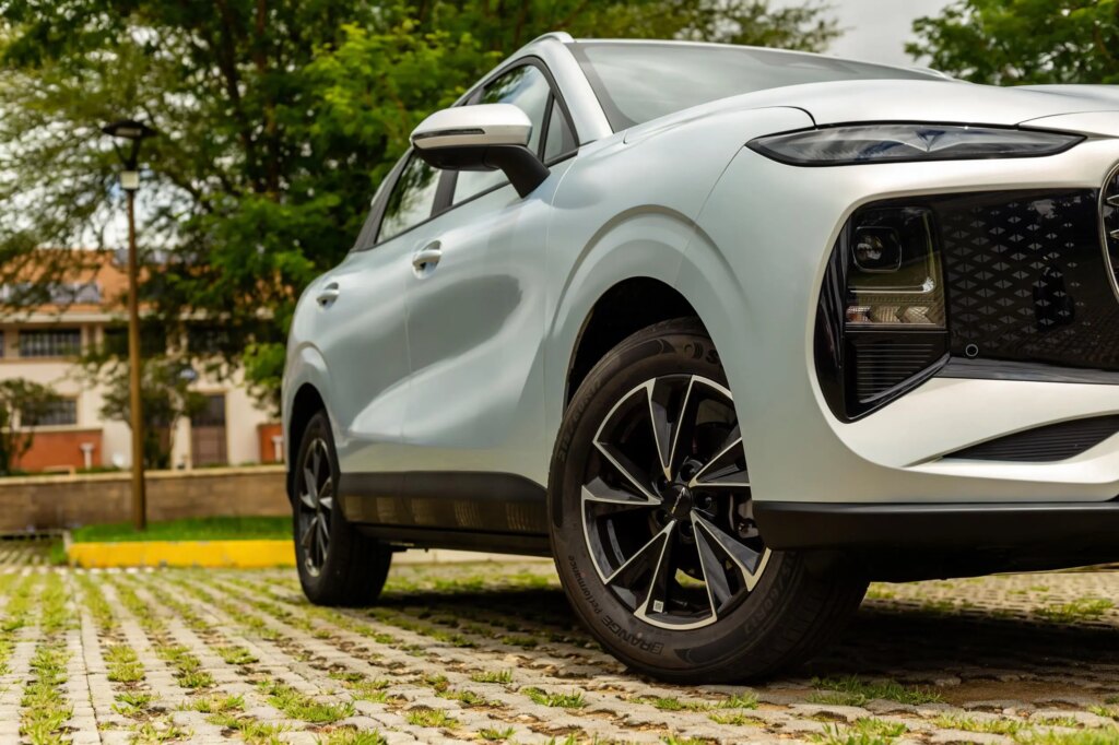Close-up side profile of a silver Lepas L4 SUV, highlighting its aerodynamic body lines and 17-inch black and silver alloy wheels on a paved driveway.